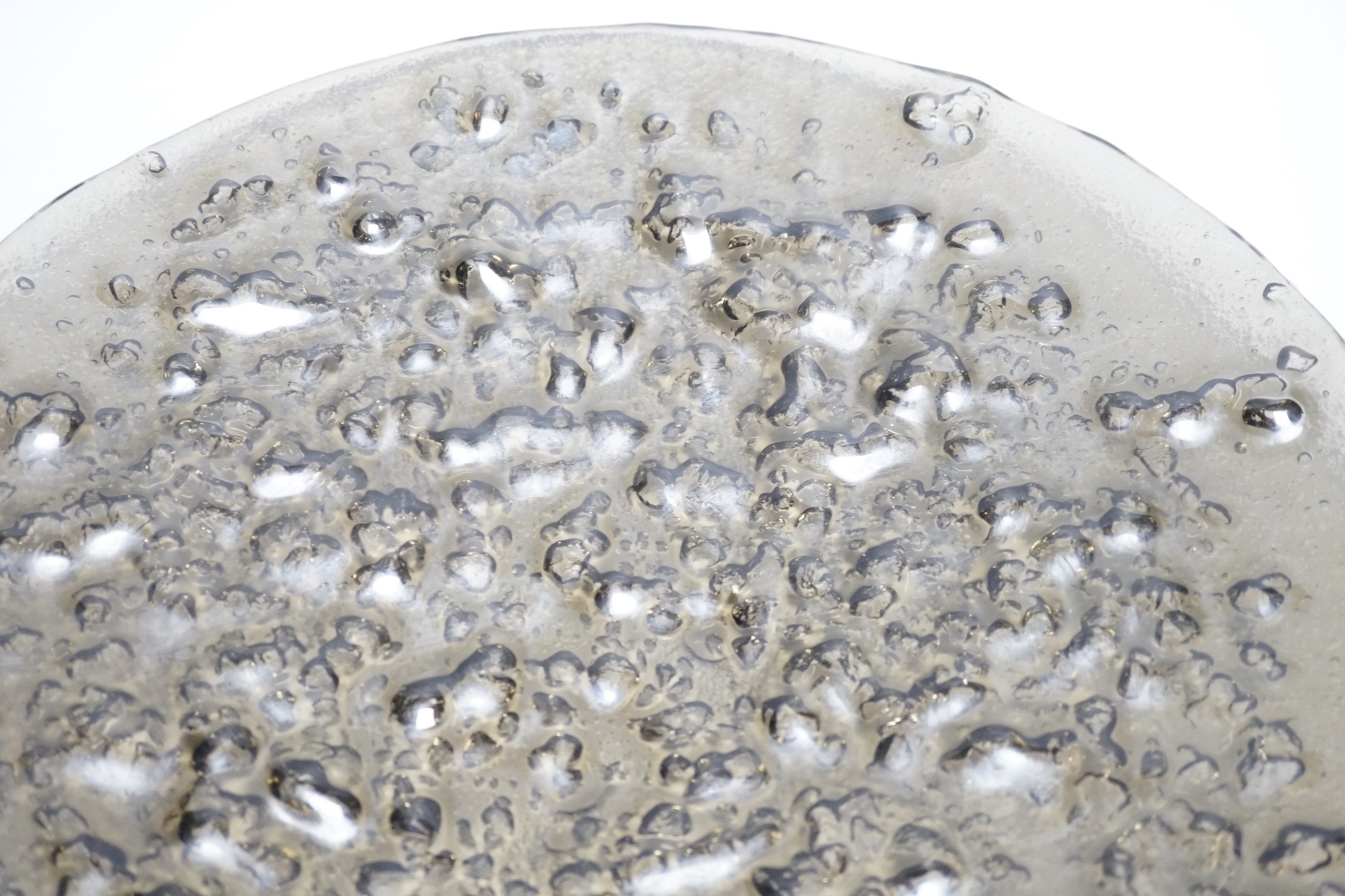 A large rubber-based pewter-coloured glass dish, 48cm